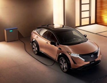 Nissan ARIYA plugged-in and charging outside a home | Friendship Nissan of Boone in Boone NC