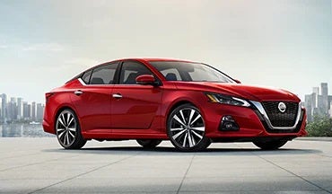 2023 Nissan Altima in red with city in background illustrating last year's 2022 model in Friendship Nissan of Boone in Boone NC